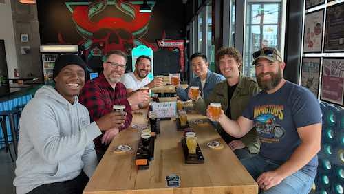 A group of men celebrating a bachelor on a brewery tour